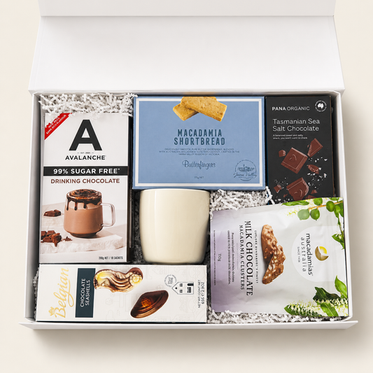 Gift box with assorted snacks including chocolate and cookies on a light background