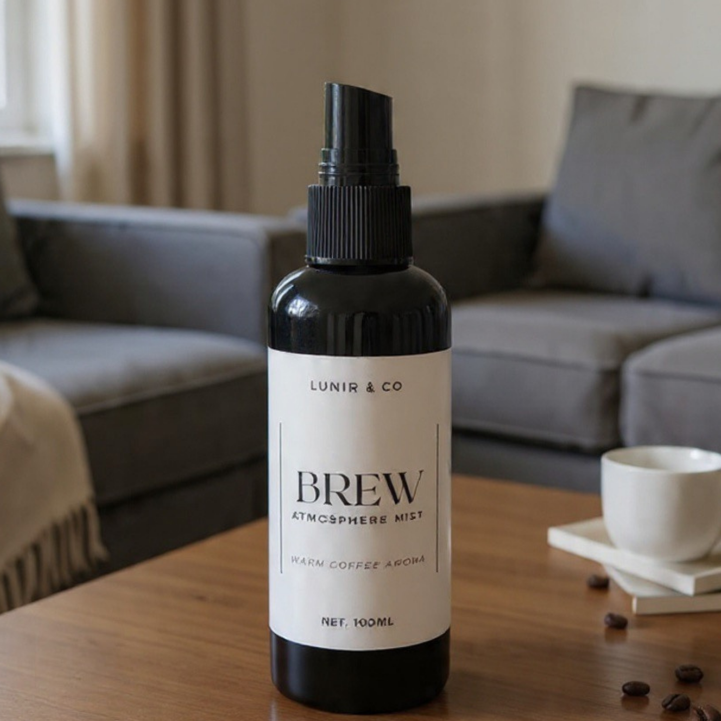 Bottle of 'Brew' atmosphere mist by Lunir & Co on a wooden table with a blurred living room background.