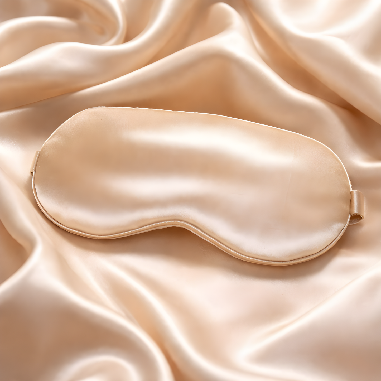 Beige satin sleep mask on a matching fabric background