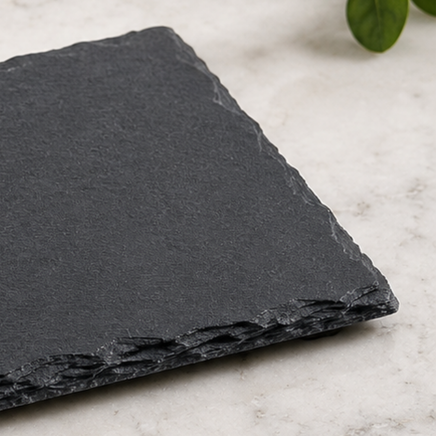 Dark gray slate stone on a light marble surface