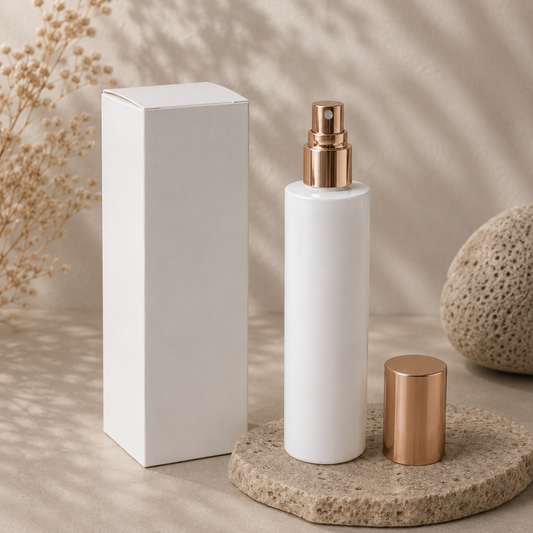 White spray bottle with bronze cap and base on a neutral background