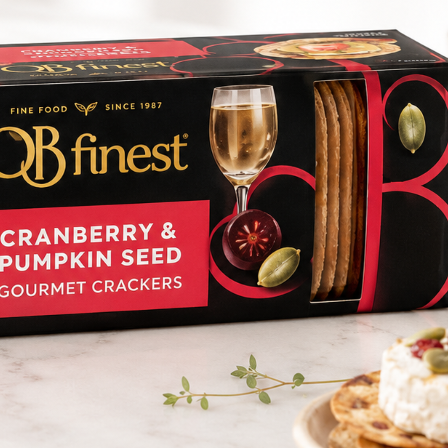 Box of OB finest cranberry & pumpkin seed gourmet crackers on a white surface.