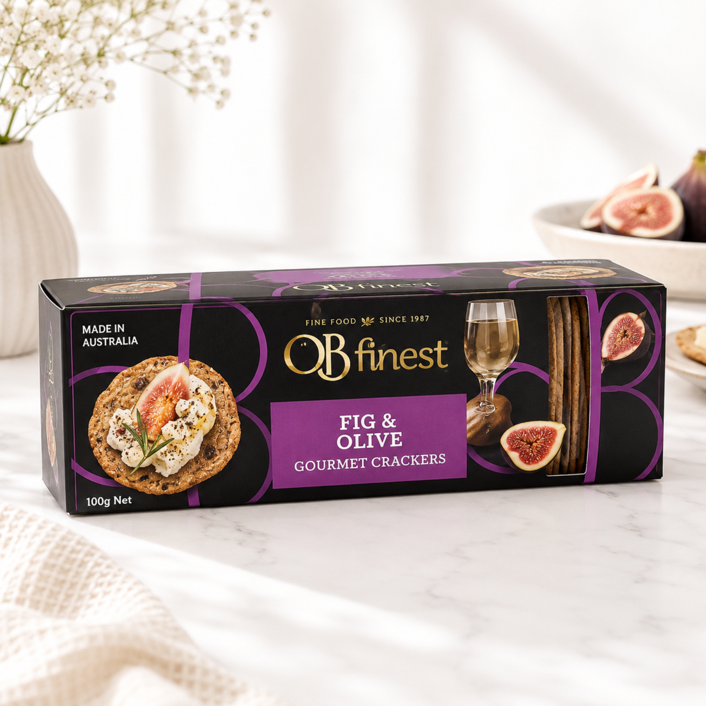 Box of O'B Finest Fig & Olive Gourmet Crackers on a marble surface with a blurred background