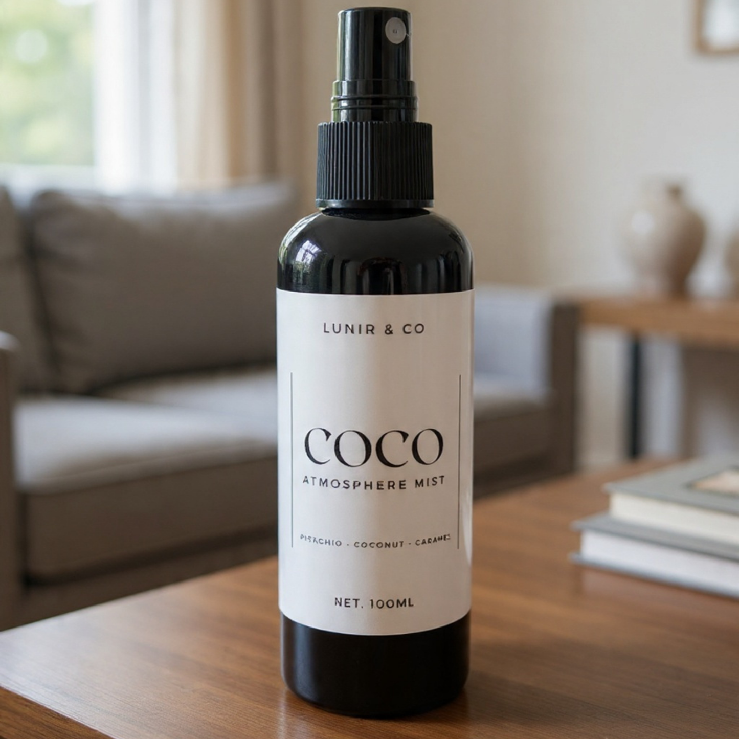 Bottle of COCO Atmosphere Mist by Lunir & Co on a wooden table with a blurred living room background