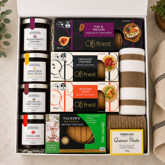 Gift set with crackers, chutneys, and a towel on a neutral background