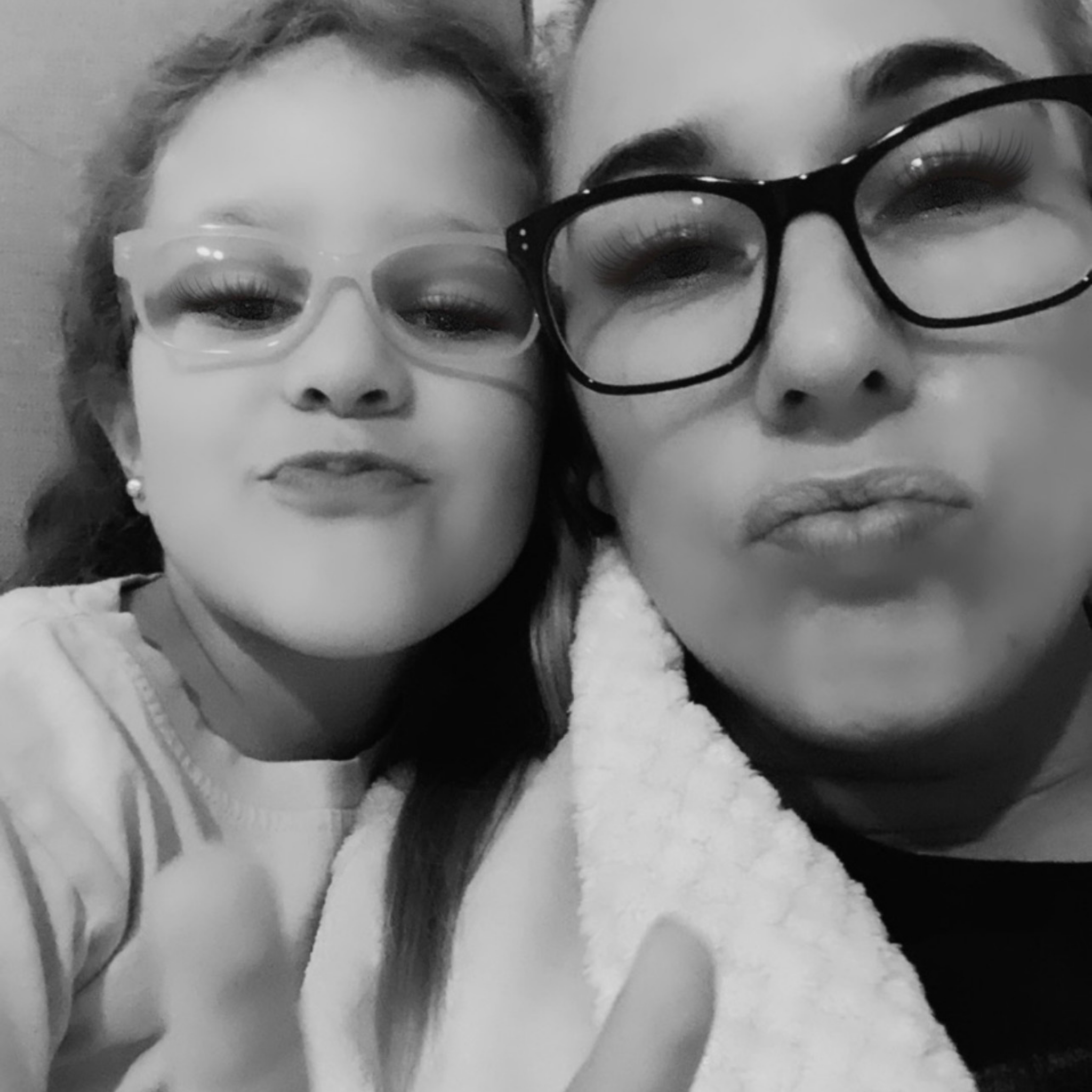 Two people posing closely together in a black and white photo.