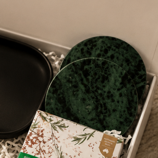 Green speckled plates and a floral-patterned box on a textured surface.