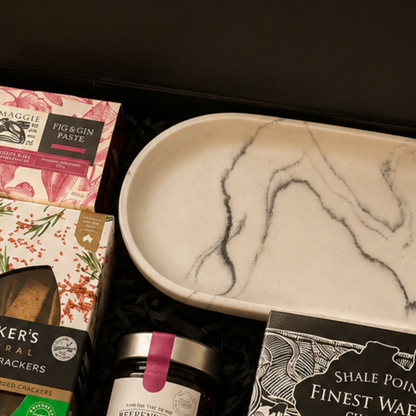 Gourmet gift set with crackers, paste, and a marble-patterned plate.