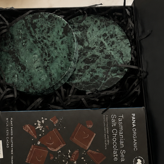 Two green marbled chocolate discs in a box with a Pana Organic Tasmanian Sea Salt Chocolate packaging.