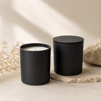 Two black candles on a neutral background with natural light