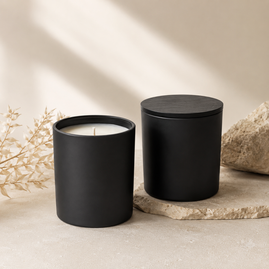 Two black candles on a neutral background with natural light
