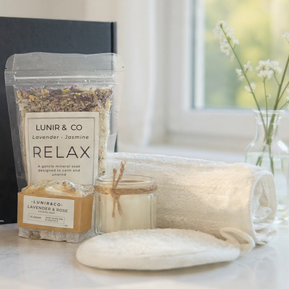 Relaxation products including a bag of LUNIR & CO lavender and jasmine relax, a candle, and soap on a table.