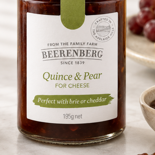 Jar of Beerenberg quince & pear for cheese on a table with grapes in the background