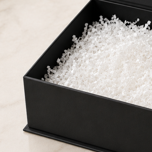 Black rectangular container filled with white perlite on a beige surface