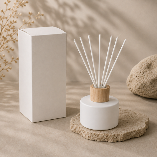 Diffuser with wooden cap and white sticks on a beige surface with a white box and rock in the background