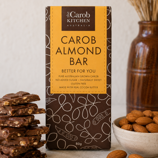 Carob Almond Bar packaging from The Carob Kitchen Australia with carob and almond pieces on a neutral background.