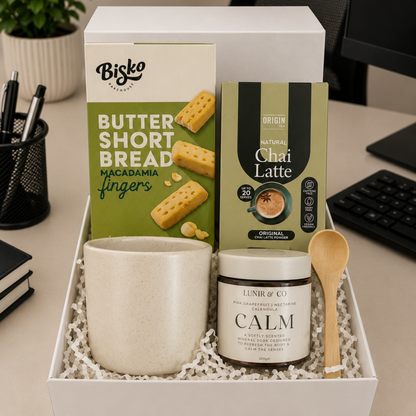 Gift set with Bisko butter shortbread, Chai Latte tea, and Calm product in a box on a desk.