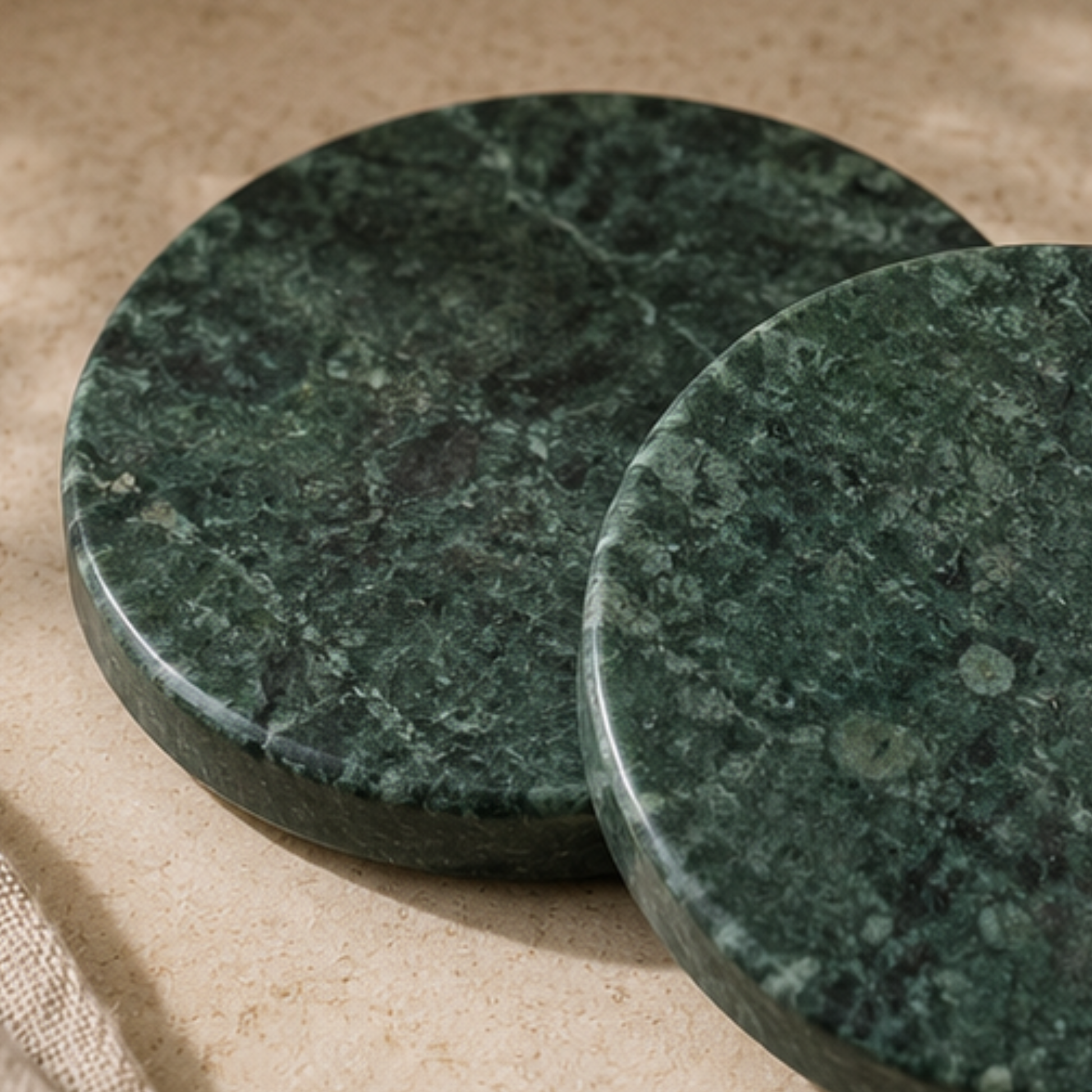 Two green marble coasters on a beige surface