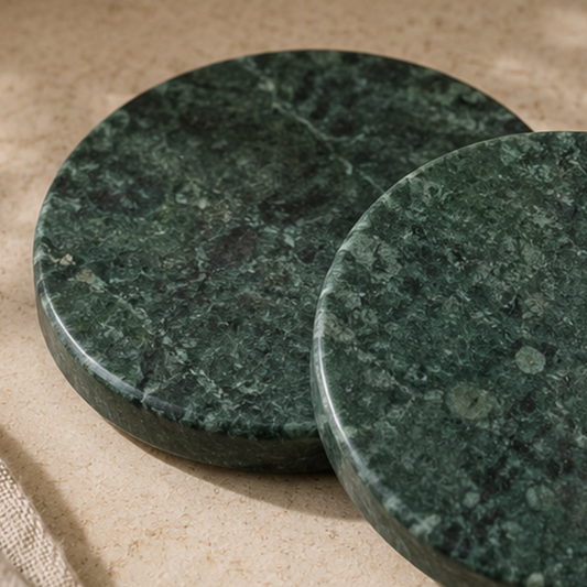 Two green marble coasters on a beige surface