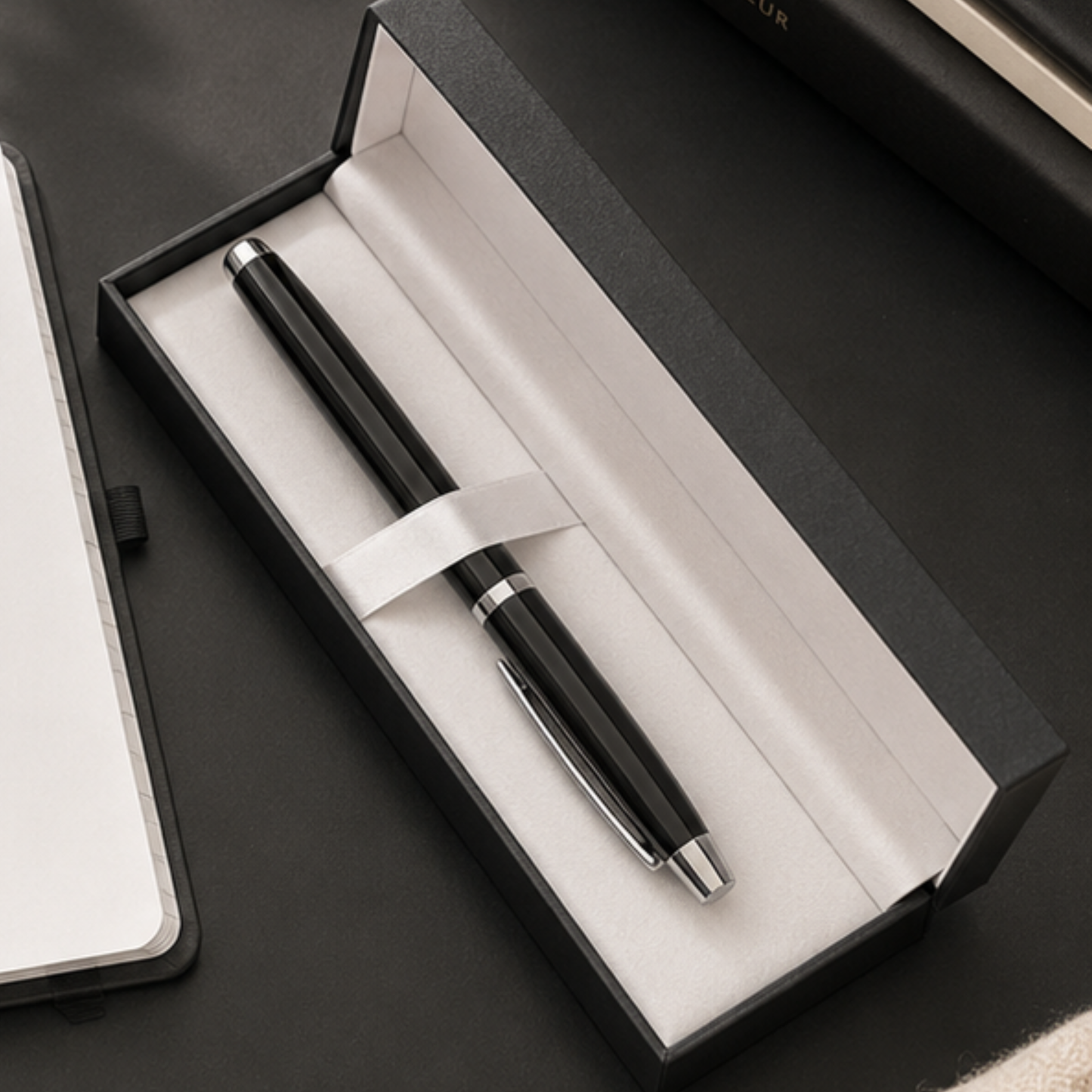 Black pen in an open box on a dark surface