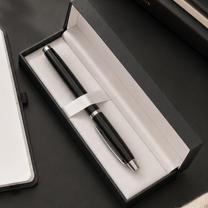 Black pen in an open box on a dark surface