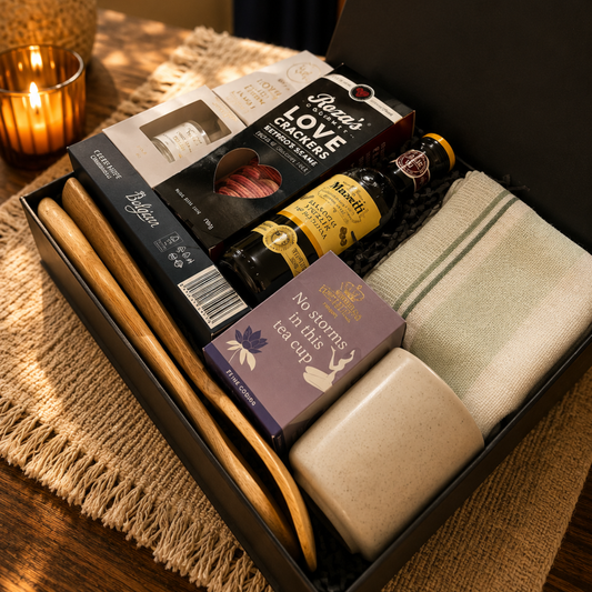 Gift box with candles, soap, and other items on a textured surface