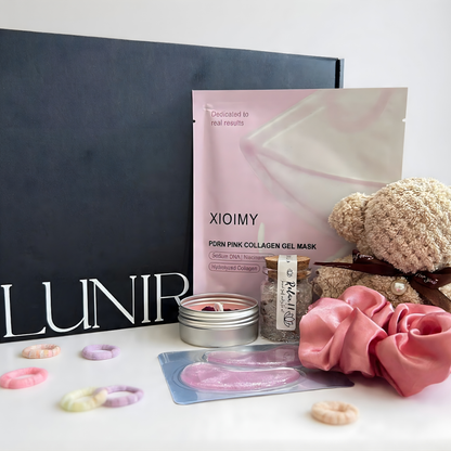 Bath product set with bath bombs and a bottle in a box on a stone surface