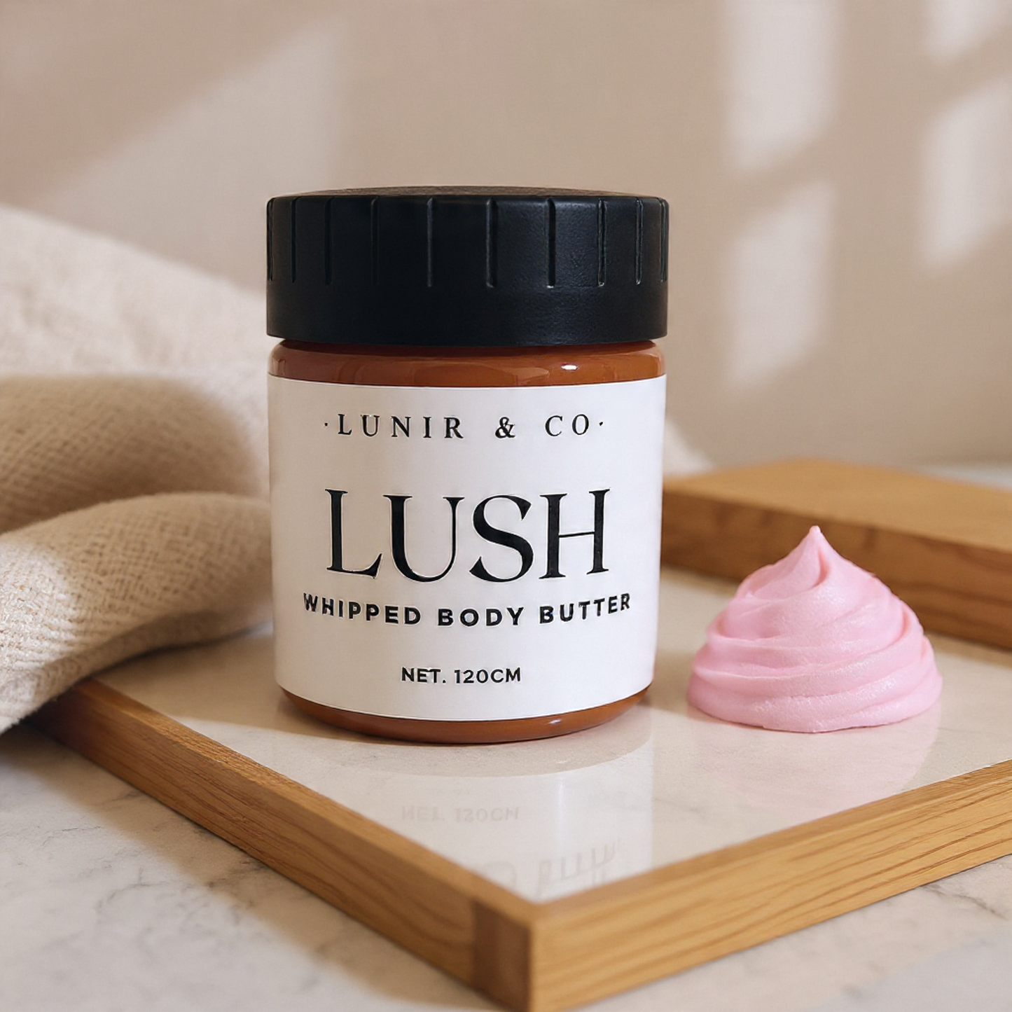 Jar of Lush whipped body butter with a pink sample on a wooden tray.