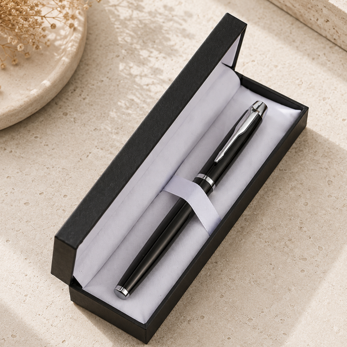 Black pen in a black box on a beige surface