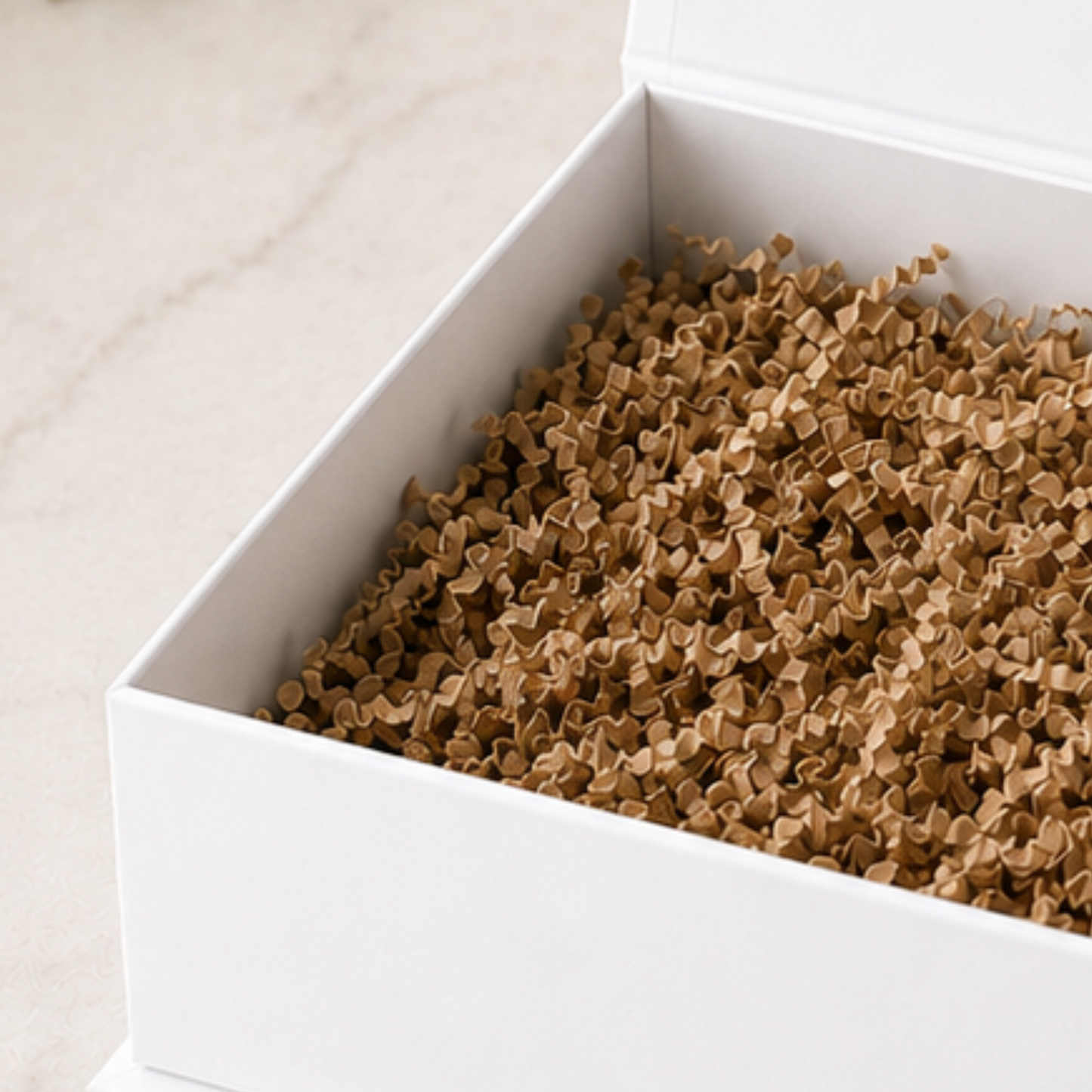 Box filled with brown paper clips on a light beige surface