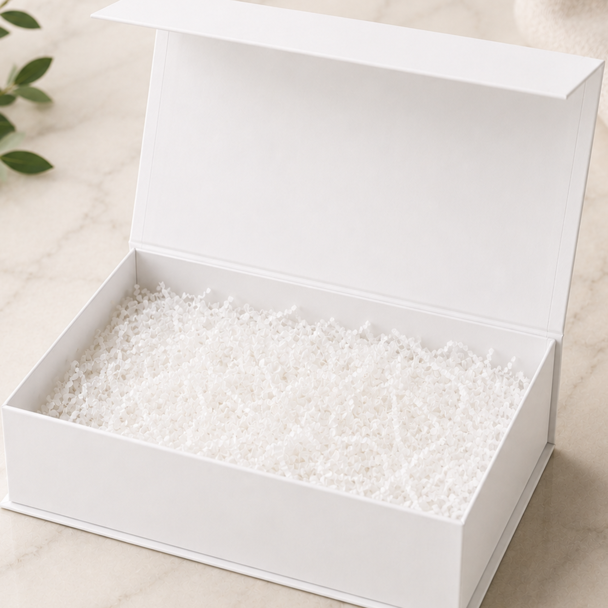 White box with small white beads inside on a light beige background