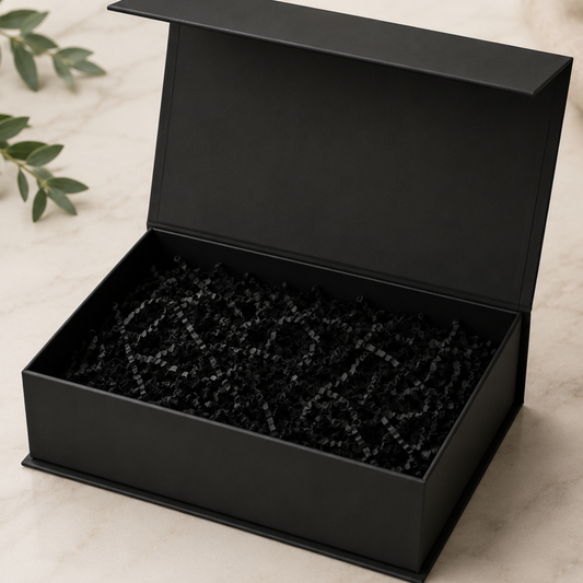 Black jewelry box with black interior on a light beige surface
