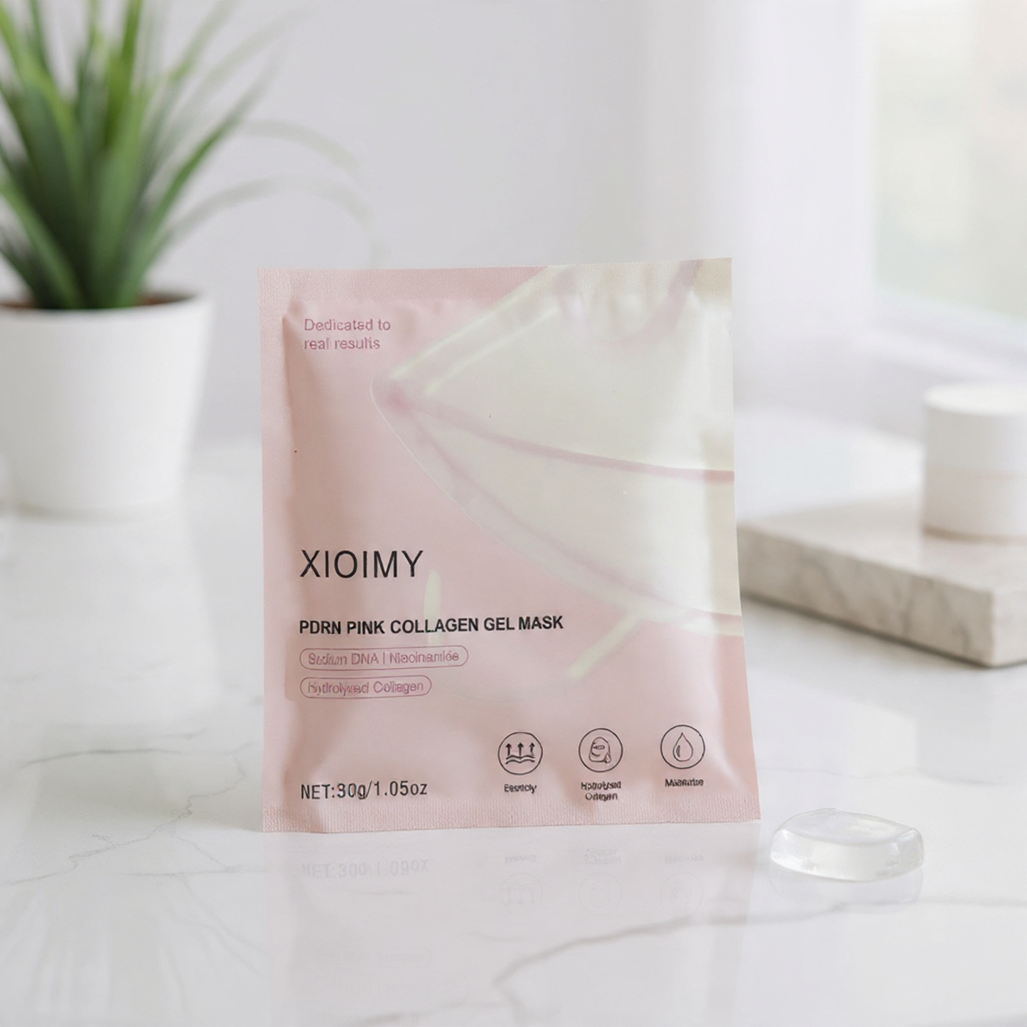 XIOIMY pink collagen gel mask packaging on a white surface with a plant in the background