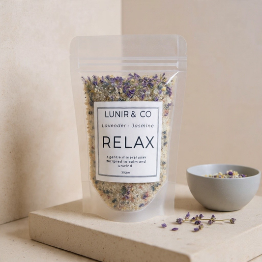 Packaged lavender and jasmine relaxing blend with a bowl of dried flowers on a neutral background
