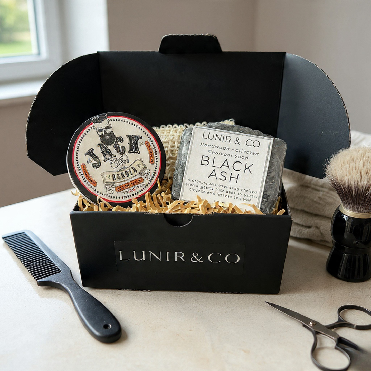 Jack the Barber products including a wax stick, candle, and after-shave balm on a marble surface.