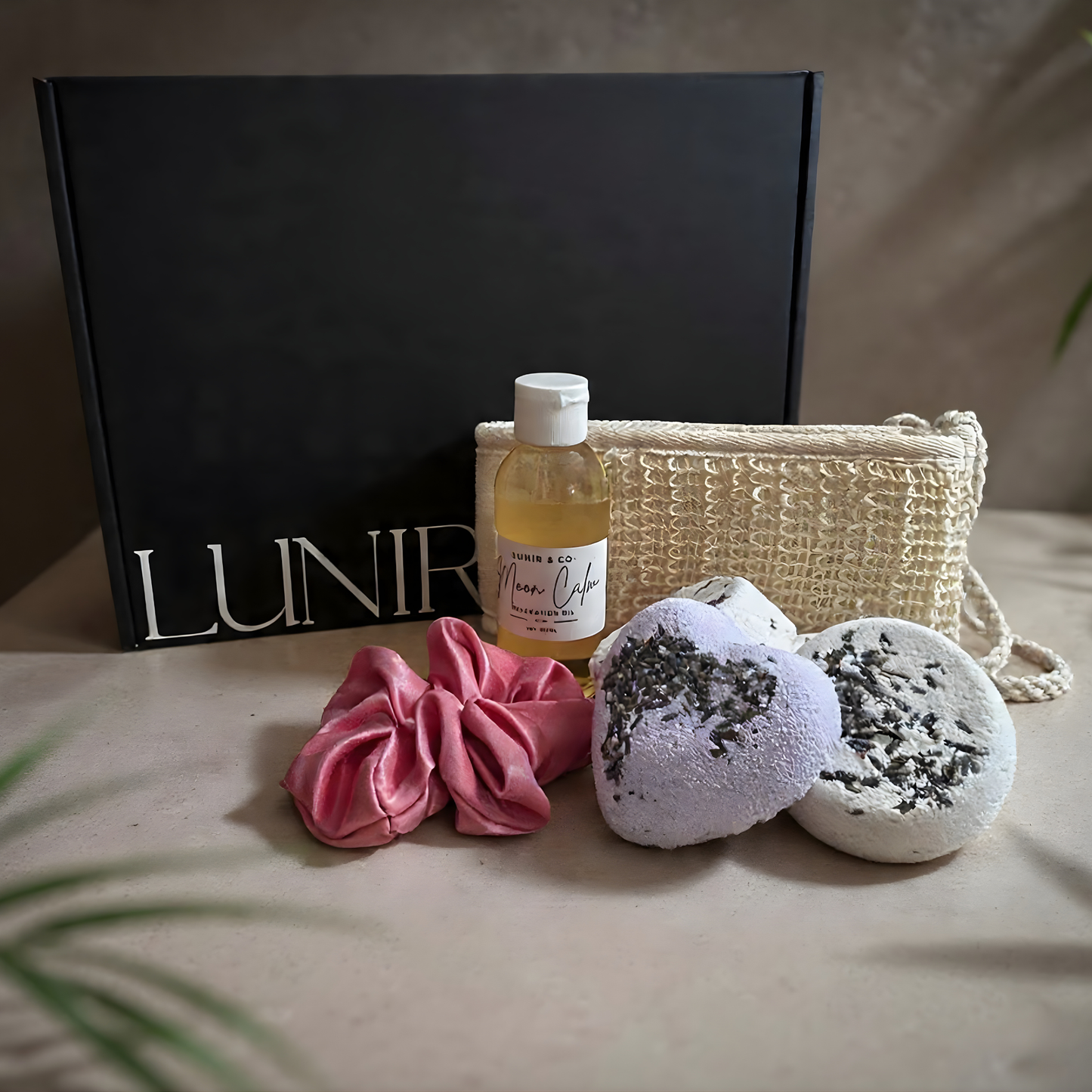 Gifting set with bottle, candle, and towel from Lunir & Co in a black box.