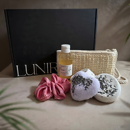 Gifting set with bottle, candle, and towel from Lunir & Co in a black box.