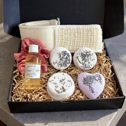 Gift basket with a bottle labeled 'LUNIR&CO' on a marble surface.