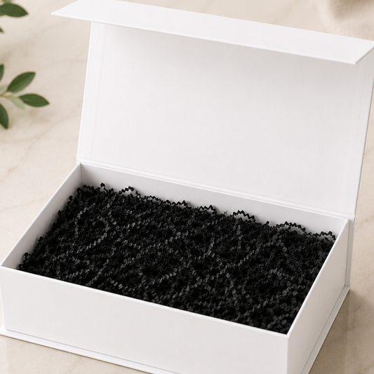 White box with black material inside on a beige surface