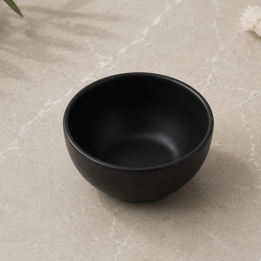 Black ceramic bowl on a light marble surface