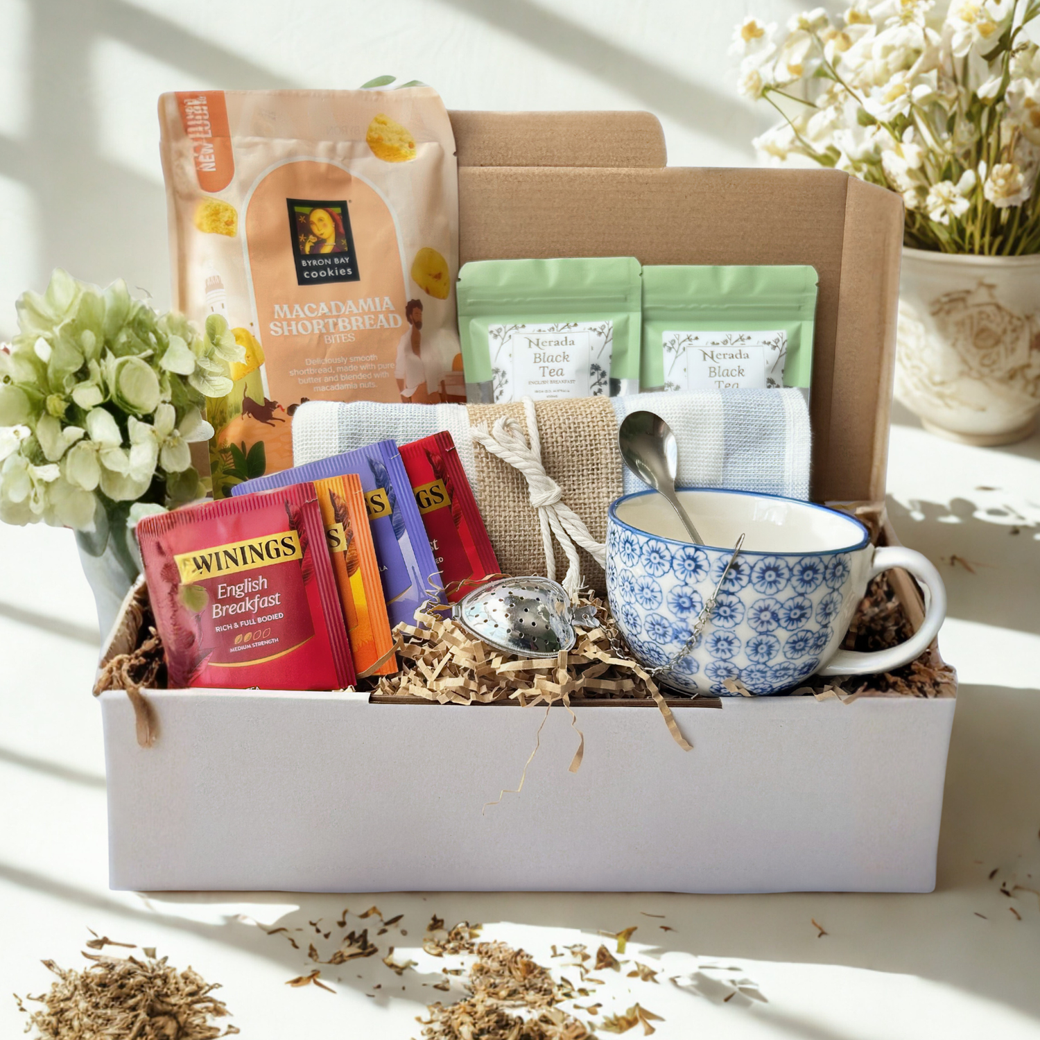 Tea gift set with a cup, tea bags, and a spoon in a decorative box.