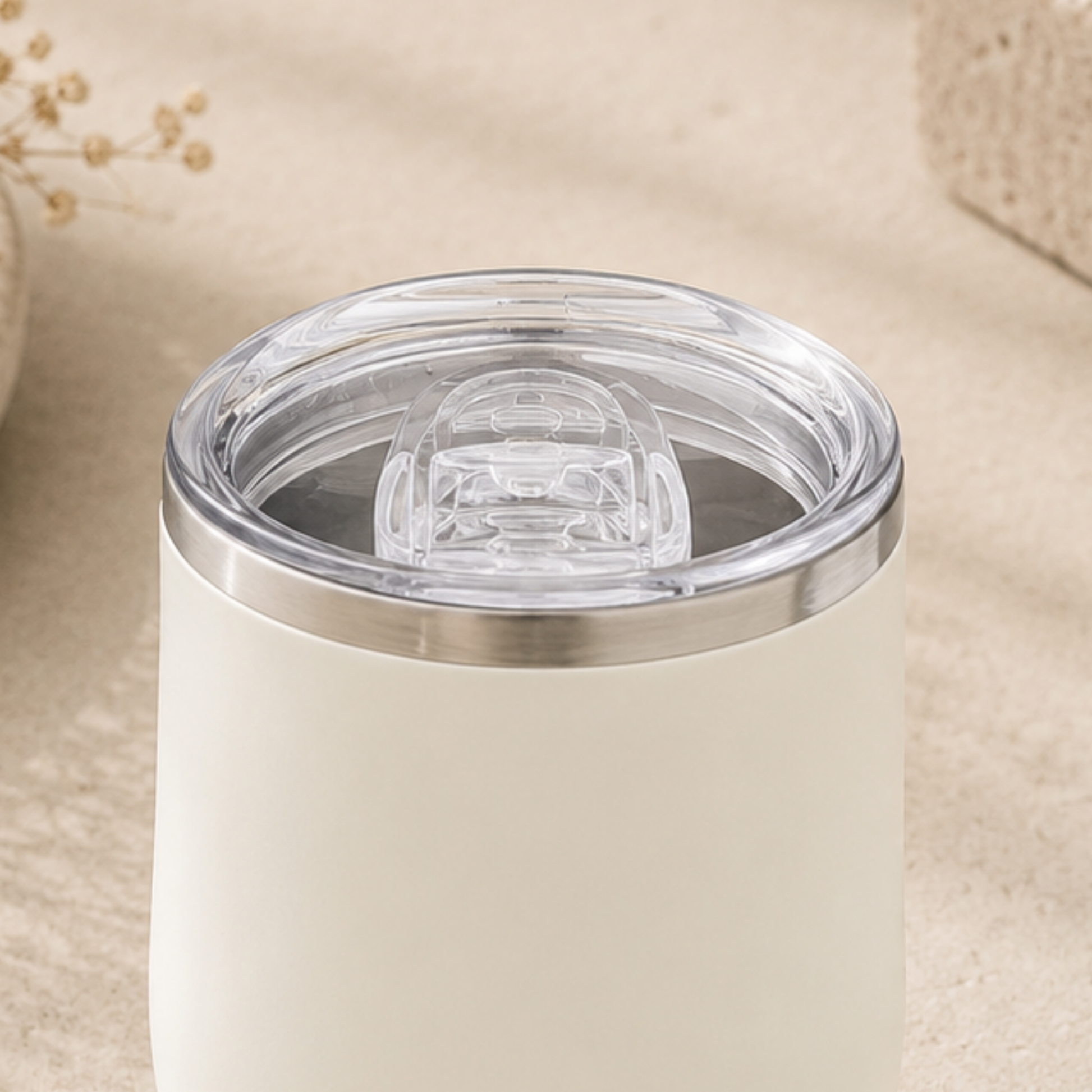 White tumbler with a clear lid on a beige background