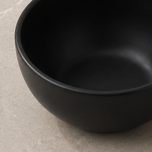 Black ceramic bowl on a beige surface