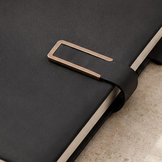 Black leather belt with a gold buckle on a dark surface