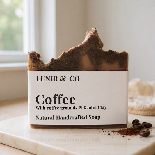 Bar of coffee soap with visible branding on a marble surface