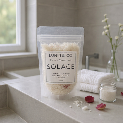 Packaged product labeled 'LUNIR & CO Solace' on a bathroom counter with towels and flowers.